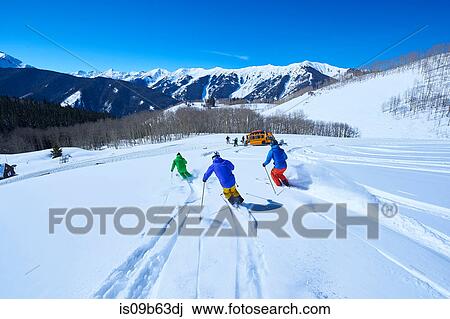 Rear view of men skiing down snow covered ski slope, Aspen, Colorado, USA View Large Photo Image Stock Image - Rear view of men skiing down snow covered ski slope, Aspen, Colorado, USA. Fotosearch