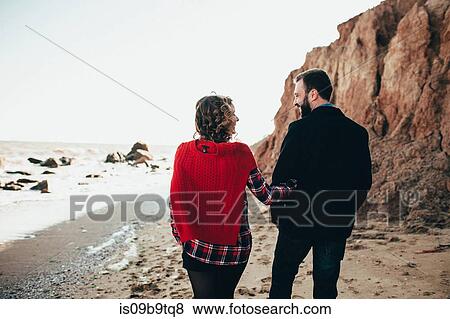 Stock Photo - Rear view of romantic mid adult couple strolling on beach, Odessa Oblast, Ukraine. Fotosearch