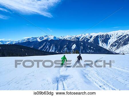 Rear view of two men skiing down snow covered ski slope, Aspen, Colorado, USA View Large Photo Image Stock Image - Rear view of two men skiing down snow covered ski slope, Aspen, Colorado, USA. Fotosearch