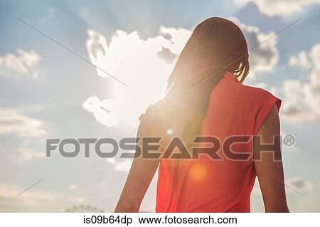 Rear view of young woman against blue sky at roof party View Large Photo Image Stock Photography - Rear view of young woman against blue sky at roof party. Fotosearch