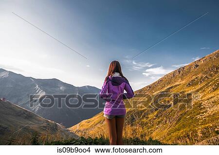 Rear view of young woman looking out on mountain landscape, Draja, Vaslui, Romania View Large Photo Image Picture - Rear view of young woman looking out on mountain landscape, Draja, Vaslui, Romania. Fotosearch