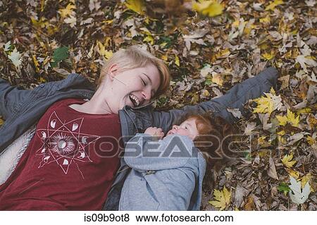 Red haired female toddler and young woman lying down on autumn leaves View Large Photo Image Stock Photo - Red haired female toddler and young woman lying down on autumn leaves. Fotosearch