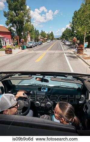 Stock Image - Road trip couple driving through town, Breckenridge, Colorado, USA. Fotosearch