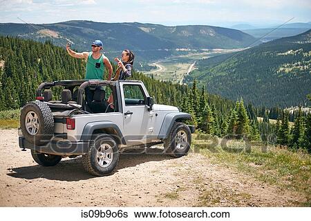 Road trip couple in parked four wheel convertible taking selfie in Rocky mountains, Breckenridge, Colorado, USA View Large Photo Image Stock Photograph - Road trip couple in parked four wheel convertible taking selfie in Rocky mountains, Breckenridge, Colorado, USA. Fotosearch