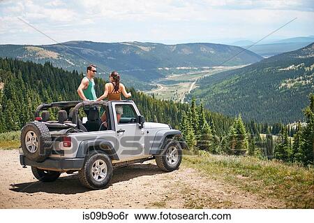 Stock Photography - Road trip couple in parked four wheel convertible in Rocky mountains, Breckenridge, Colorado, USA. Fotosearch