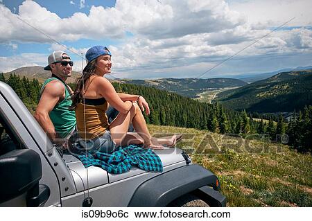 Road trip couple looking from car hood in Rocky Mountains, Breckenridge, Colorado, USA View Large Photo Image Stock Image - Road trip couple looking from car hood in Rocky Mountains, Breckenridge, Colorado, USA. Fotosearch