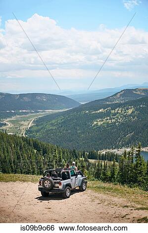 Road trip couple looking out at mountains from off road vehicle hood, Breckenridge, Colorado, USA View Large Photo Image Stock Photograph - Road trip couple looking out at mountains from off road vehicle hood, Breckenridge, Colorado, USA. Fotosearch