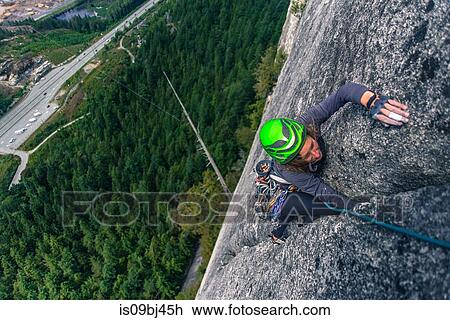 Stock Image - Rock climber climbing up The Chief, Squamish, Canada. Fotosearch