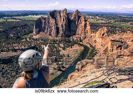 Stock Photo - Rock climber pointing at rock formation, Smith Rock State Park, Terrebonne, Oregon, United States. Fotosearch