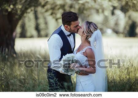Romantic bride and groom kissing in woodland View Large Photo Image Stock Image - Romantic bride and groom kissing in woodland. Fotosearch