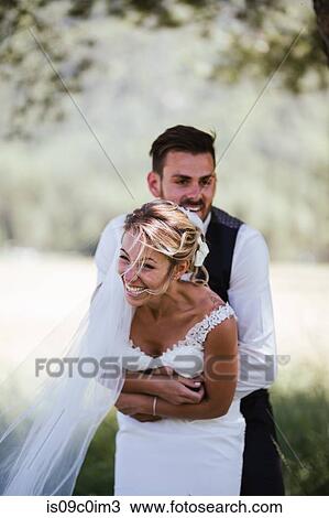 Romantic groom hugging bride from behind in woodland View Large Photo Image Stock Image - Romantic groom hugging bride from behind in woodland. Fotosearch