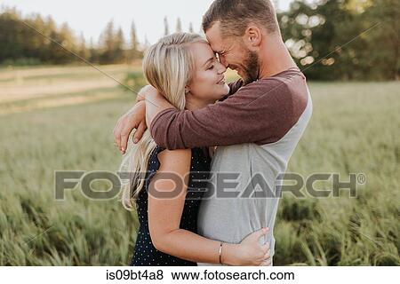 Romantic man and girlfriend hugging in field of long grass View Large Photo Image Stock Photo - Romantic man and girlfriend hugging in field of long grass. Fotosearch