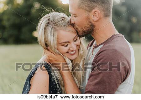 Romantic man kissing girlfriend on forehead in field View Large Photo Image Stock Photo - Romantic man kissing girlfriend on forehead in field. Fotosearch