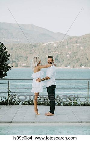 Picture - Romantic mid adult couple barefoot on poolside, portrait, Stresa, Piemonte, Italy. Fotosearch