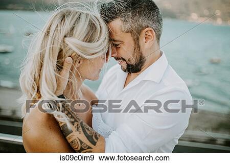 Romantic mid adult couple face to face on lakeside View Large Photo Image Stock Photo - Romantic mid adult couple face to face on lakeside. Fotosearch