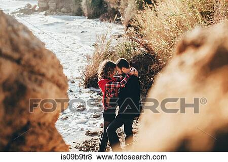 Stock Photo - Romantic mid adult couple with arms around each other on beach, Odessa Oblast, Ukraine. Fotosearch
