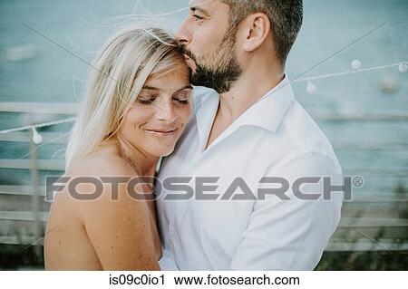 Romantic mid adult man kissing girlfriend's forehead on lakeside, Stresa, Piemonte, Italy View Large Photo Image Stock Image - Romantic mid adult man kissing girlfriend's forehead on lakeside, Stresa, Piemonte, Italy. Fotosearch