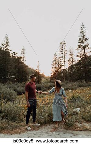 Stock Photo - Romantic young couple holding hands in rural valley, Mineral King, California, USA. Fotosearch