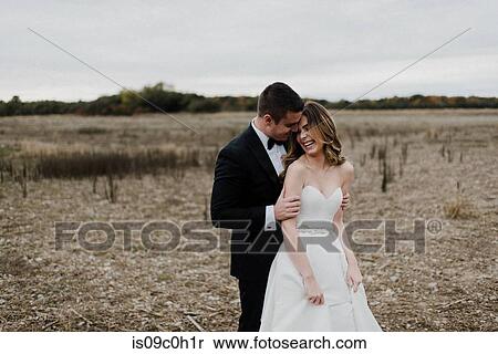 Stock Photography - Romantic young couple in field on wedding day. Fotosearch