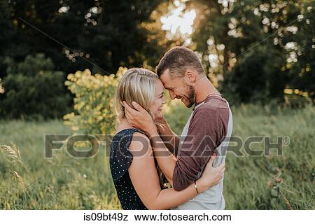 Romantic young woman and boyfriend face to face in field at sunset View Large Photo Image Stock Photo - Romantic young woman and boyfriend face to face in field at sunset. Fotosearch