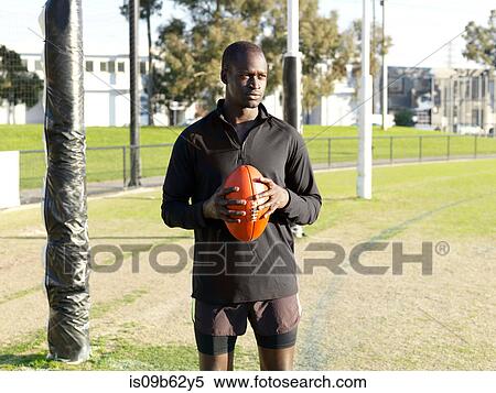 Rugby player holding ball on field View Large Photo Image Stock Photography - Rugby player holding ball on field. Fotosearch