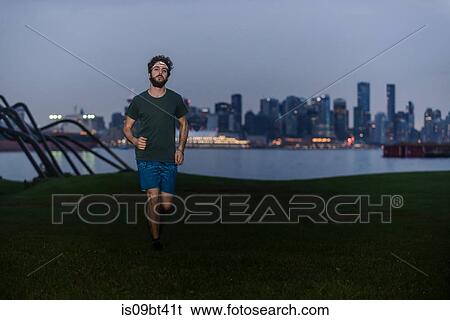 Stock Photograph - Runner with headlamp in urban North Vancouver, Canada. Fotosearch