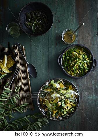 Rustic low key still life with bowls of curry leaf fish salad and green bean thoran on table, overhead view View Large Photo Image Stock Photography - Rustic low key still life with bowls of curry leaf fish salad and green bean thoran on table, overhead view. Fotosearch