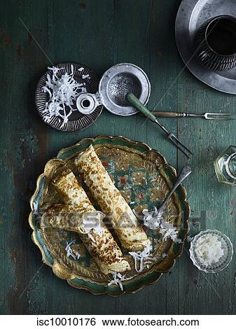 Rustic low key still life with plate of grated coconut pancakes on table, overhead view View Large Photo Image Stock Photograph - Rustic low key still life with plate of grated coconut pancakes on table, overhead view. Fotosearch