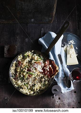 Rustic low key still life with skillet of risotto, capers and espresso on table, overhead view View Large Photo Image Stock Photo - Rustic low key still life with skillet of risotto, capers and espresso on table, overhead view. Fotosearch