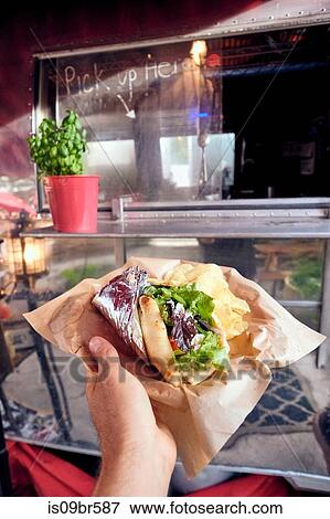 Stock Photo - Salad wrap being collected from window of food truck. Fotosearch