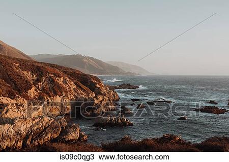 Stock Image - Scenic view of cliffs and misty coastline, Big Sur, California, United States. Fotosearch