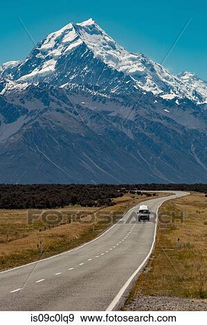 Scenic view of rural road leading towards mountains, Wanaka, Taranaki, New Zealand View Large Photo Image Stock Photo - Scenic view of rural road leading towards mountains, Wanaka, Taranaki, New Zealand. Fotosearch