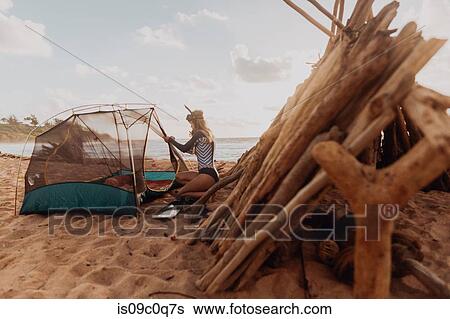 Stock Photograph - Scuba diver camping on sandy beach, Princeville, Hawaii, US. Fotosearch