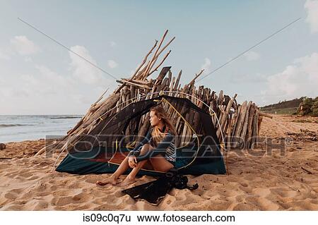Stock Photograph - Scuba diver camping on sandy beach, Princeville, Hawaii, US. Fotosearch