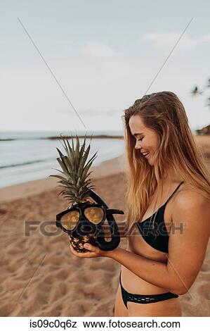 Stock Photo - Scuba diver putting goggles on pineapple, Princeville, Hawaii, US. Fotosearch