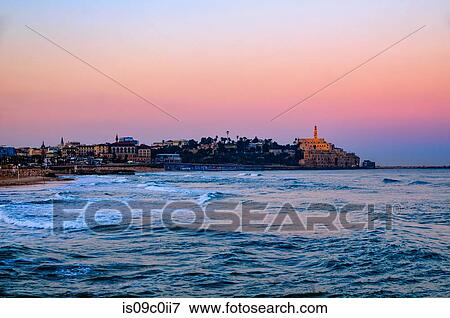 Stock Photo - Seascape with distant view of old port skyline and Church of St Peter at dawn, Jaffa, Tel Aviv, Israel. Fotosearch