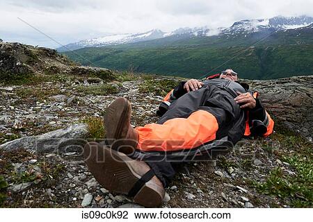Senior male hiker taking a break lying on top of mountain, Valdez, Alaska, USA View Large Photo Image Stock Image - Senior male hiker taking a break lying on top of mountain, Valdez, Alaska, USA. Fotosearch