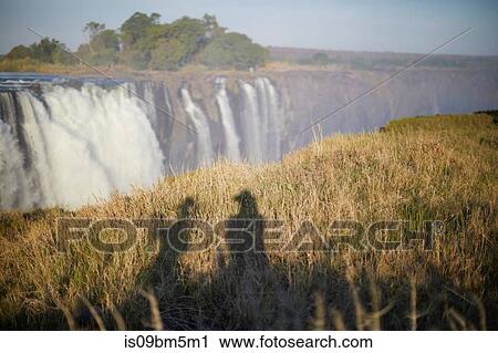 Shadow of tourists on grass, Victoria Falls, Zimbabwe View Large Photo Image Stock Image - Shadow of tourists on grass, Victoria Falls, Zimbabwe. Fotosearch