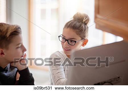 Siblings using computer at home View Large Photo Image Stock Image - Siblings using computer at home. Fotosearch