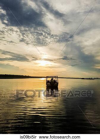 Silhouette of boat on river at sunset, Chobe National Park, Botswana View Large Photo Image Stock Photography - Silhouette of boat on river at sunset, Chobe National Park, Botswana. Fotosearch
