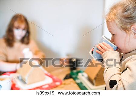 Sisters decorating gingerbread house for Christmas View Large Photo Image Stock Image - Sisters decorating gingerbread house for Christmas. Fotosearch