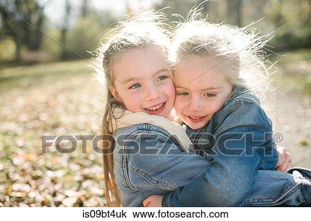 Sisters hugging in forest View Large Photo Image Stock Image - Sisters hugging in forest. Fotosearch