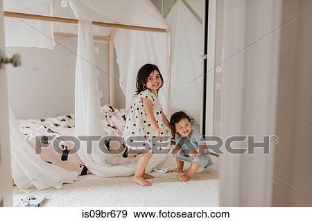 Sisters playing on bed View Large Photo Image Stock Photo - Sisters playing on bed. Fotosearch