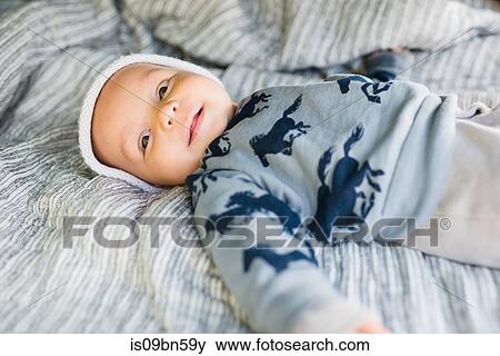 Smiling baby boy lying on bed View Large Photo Image Stock Photo - Smiling baby boy lying on bed. Fotosearch