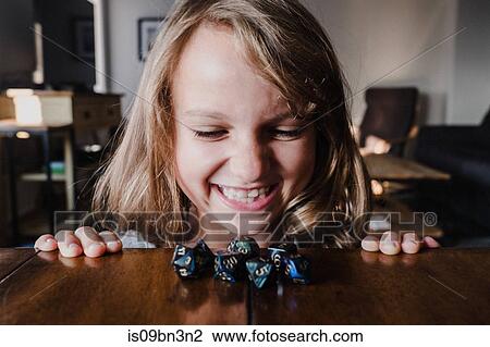 Smiling girl at table looking at role playing dice, close up View Large Photo Image Stock Image - Smiling girl at table looking at role playing dice, close up. Fotosearch