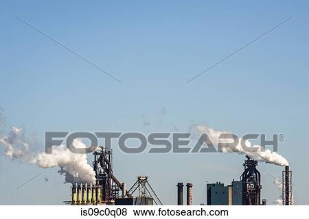 Smokestacks from steel industry blast-furnaces against blue sky, Netherlands View Large Photo Image Stock Photo - Smokestacks from steel industry blast-furnaces against blue sky, Netherlands. Fotosearch