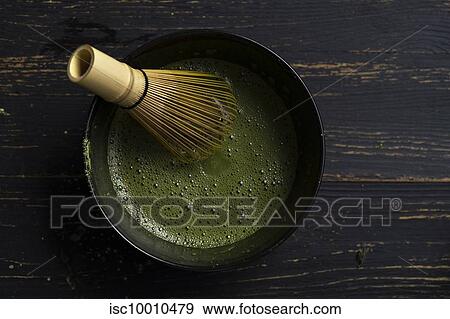 Still life of matcha tea preparation with whisk in bowl of matcha tea, overhead view, low key View Large Photo Image Stock Photo - Still life of matcha tea preparation with whisk in bowl of matcha tea, overhead view, low key. Fotosearch