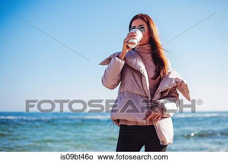 Stylish mid adult woman on beach drinking takeaway coffee, Odessa, Odeska Oblast, Ukraine View Large Photo Image Picture - Stylish mid adult woman on beach drinking takeaway coffee, Odessa, Odeska Oblast, Ukraine. Fotosearch