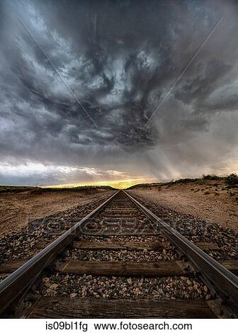 Stock Image - Supercell rotates at sunset over infinite stretch of train tracks, Arriba, Colorado, US. Fotosearch