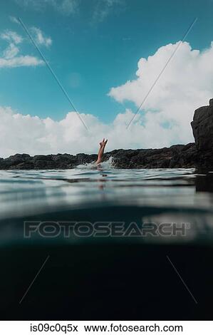 Swimmer diving off rocks into sea, Princeville, Hawaii, US View Large Photo Image Stock Photo - Swimmer diving off rocks into sea, Princeville, Hawaii, US. Fotosearch